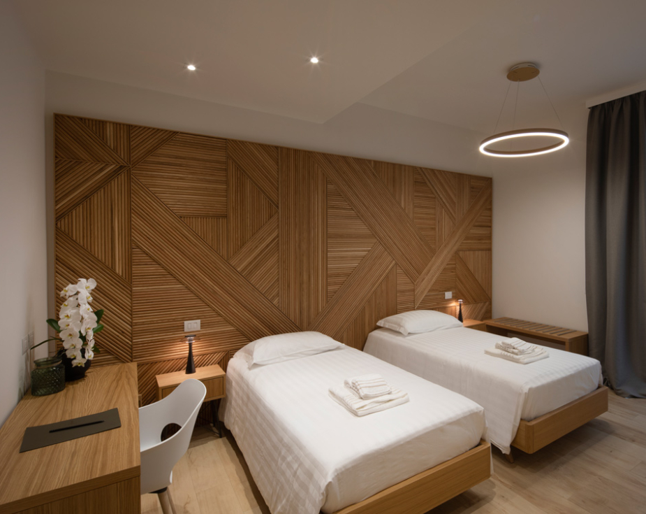 Modern twin bedroom with wooden decor and en-suite bathroom.