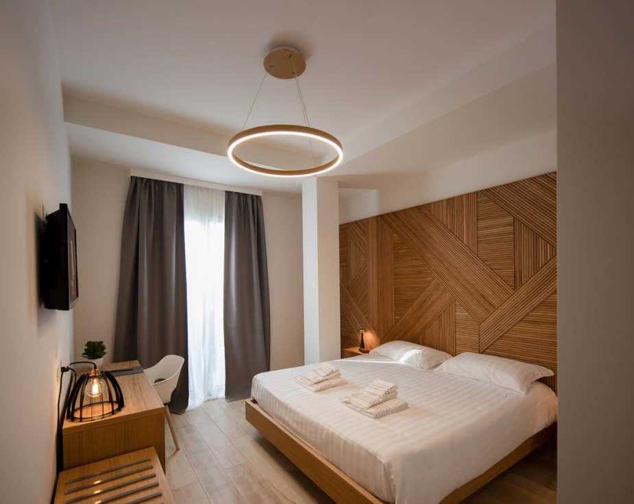 Modern bedroom with wooden accents, minimalist design, and circular ceiling light.